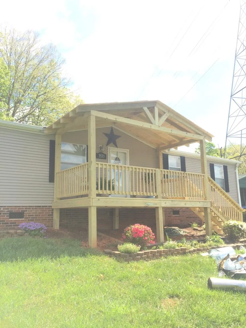 New gabled porch roof and deck railing added to a ranch home in Minier
